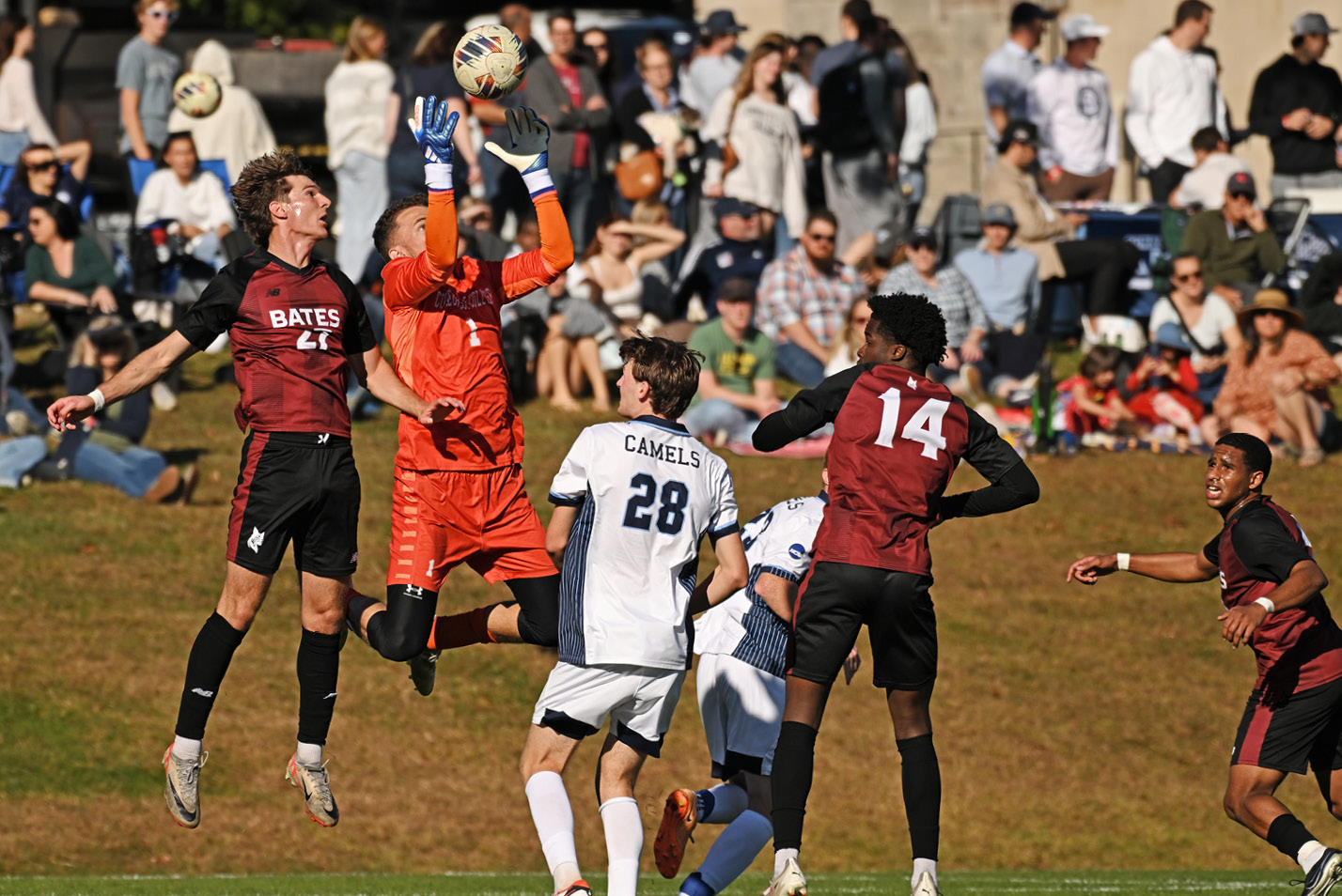 A goalie makes a jumping save during men's soccer vs. Bates at Fall Weekend 2024