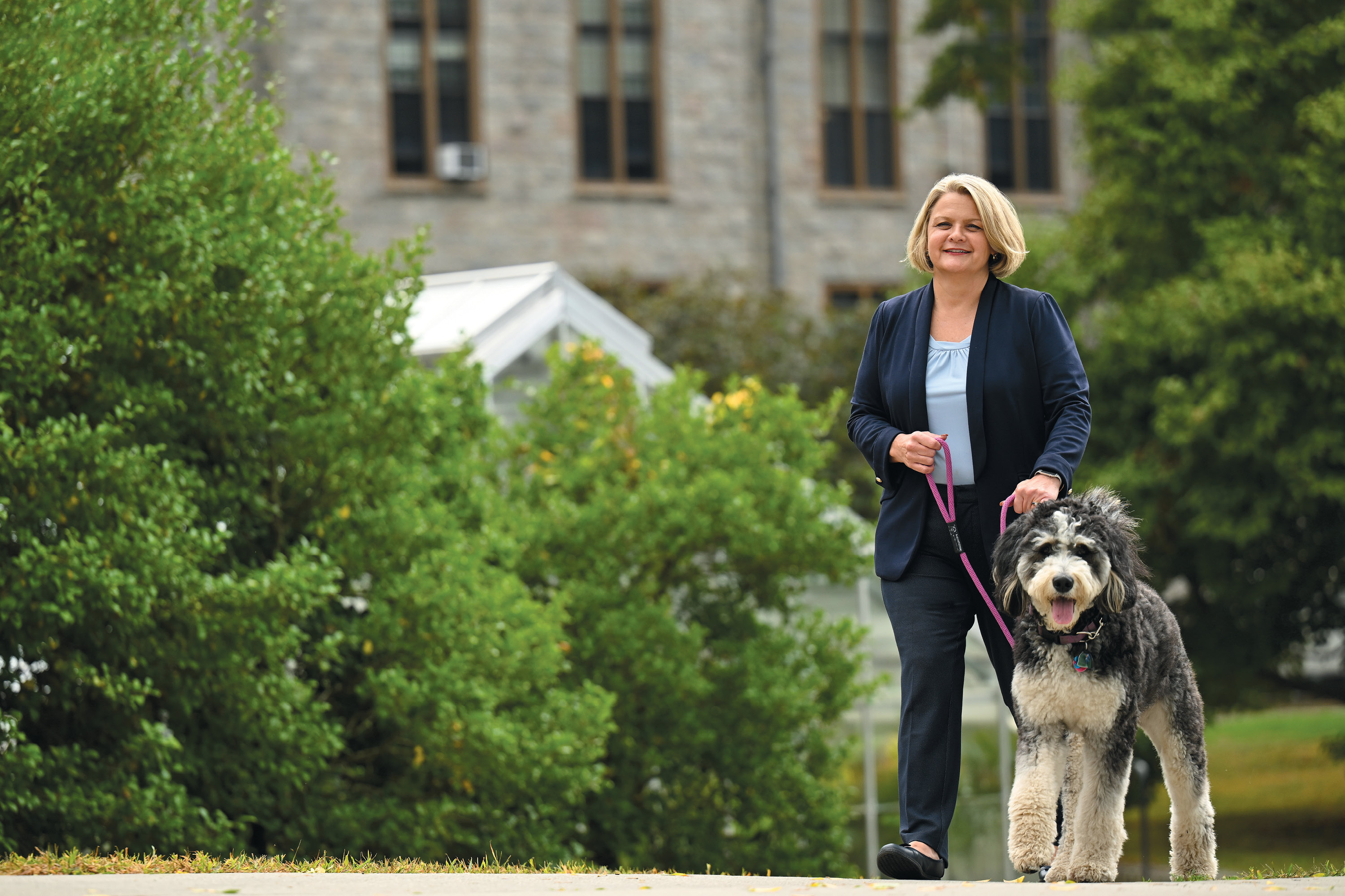 President Andrea Chapdelaine and her dog Koda walk across Tempel Green