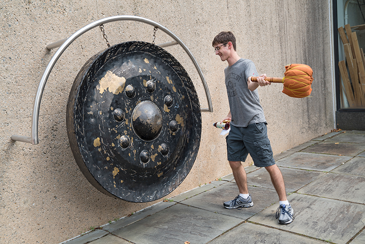 A student bangs the gong. 