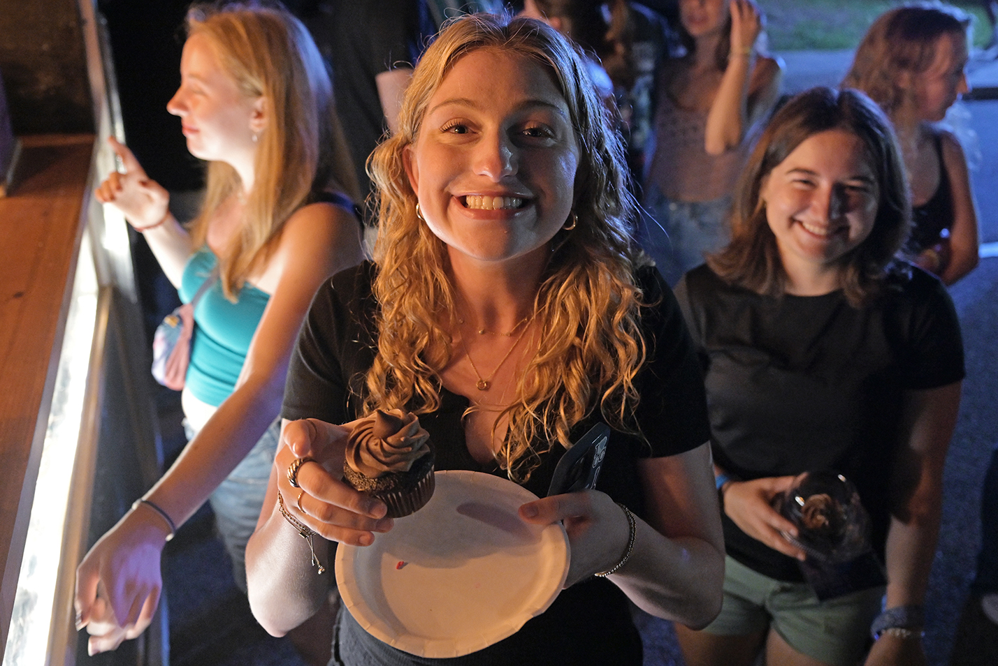 A student holds up a cupcake.