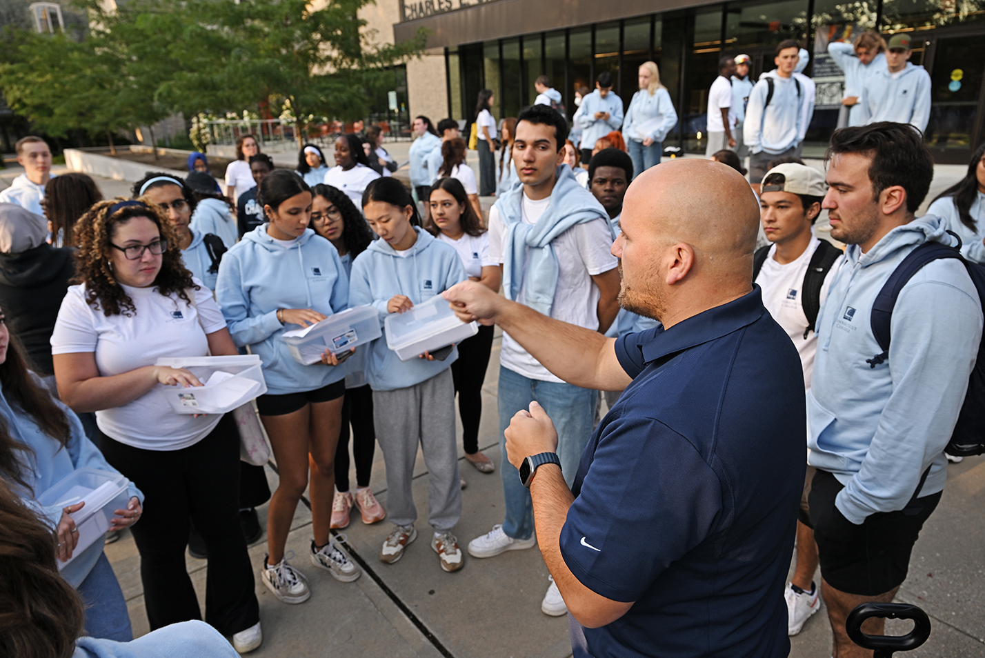 The head of residence life hands out totes with keys for new students.