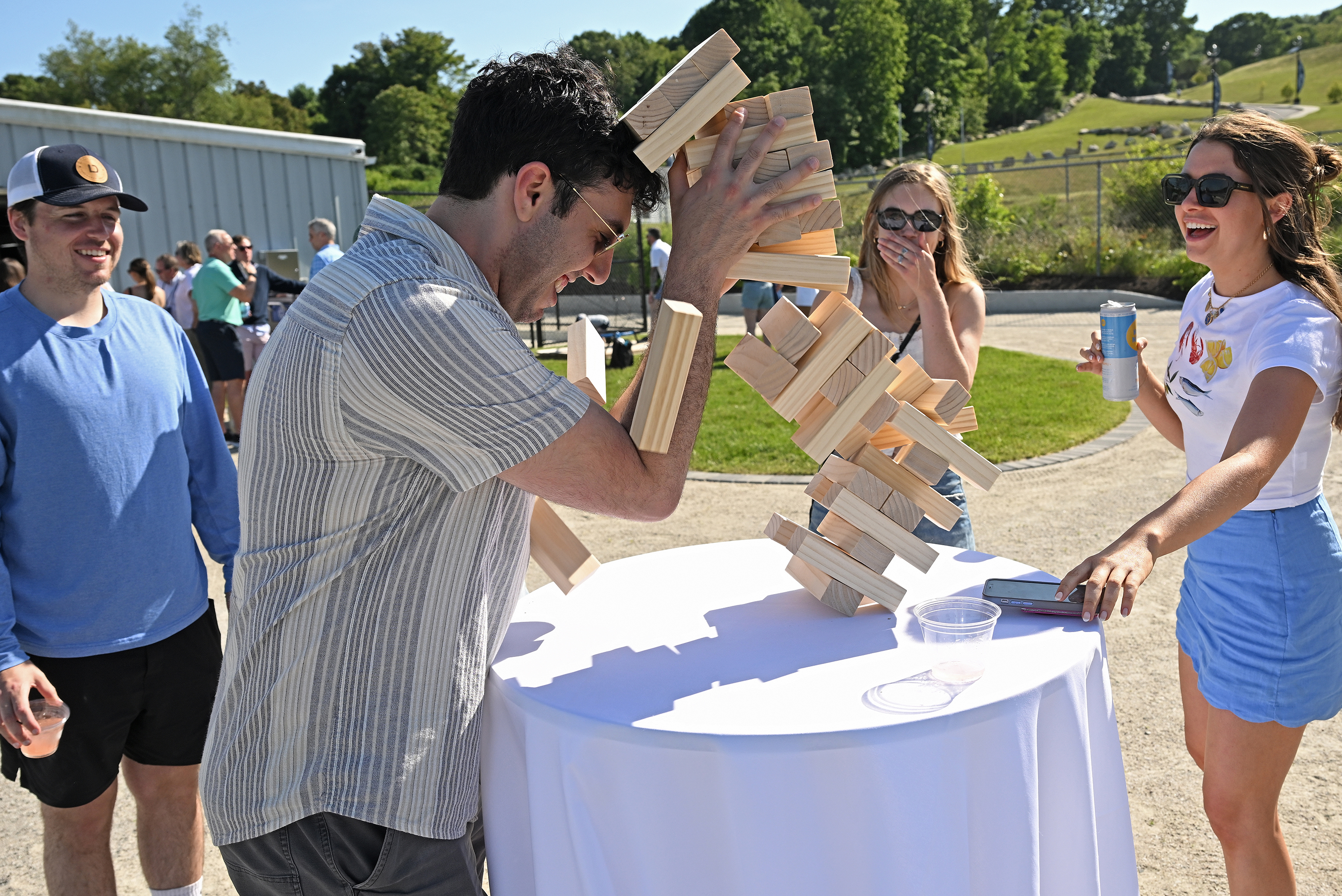 A man catches just the top section of a collapsing JENGA game.